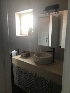 y baño con lavabo de piedra y espejo. en Casa da Ilha do Baleal, en Baleal