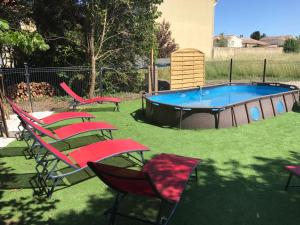 grupa krzeseł i basen na dziedzińcu w obiekcie Villa, piscine, jardin, barbecue, proche centre w Orange