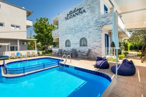 a swimming pool in front of a building at Studios Suzanna in Potos