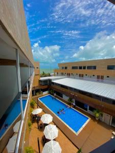 an overhead view of a building with a pool and umbrellas at Bessa Beach Hotel in João Pessoa