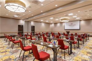 a conference room with tables and red chairs at Crowne Plaza Shenandoah - The Woodlands in The Woodlands