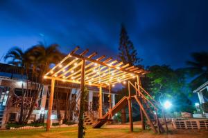 un parque infantil con estructura de madera por la noche en Pousada Bicho Preguiça, en Pipa