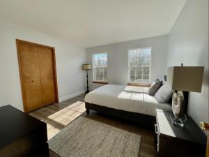 um quarto com uma cama e duas janelas em Modern Poconos home, game room, pool, waterparks em Albrightsville