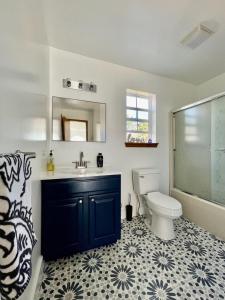 a bathroom with a blue sink and a toilet at Modern Poconos home, game room, pool, waterparks in Albrightsville +30 photos