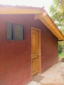 a small red house with a door and windows at La Casita de Chocolate 3 in Bogotá