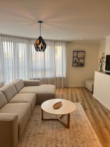een woonkamer met een bank en een tafel bij Portofino - luxe appartement met lateraal zeezicht in Oostende
