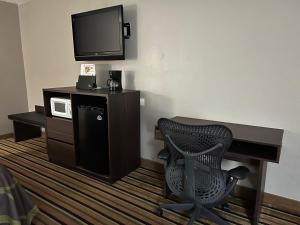 a room with a desk and a chair and a television at Super 8 by Wyndham Norcross/I-85 Atlanta in Norcross