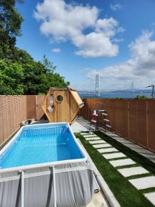 a backyard with a swimming pool and a dog house at アナザーオーシャン淡路ヴィラ in Awaji