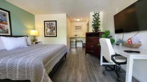 a bedroom with a bed and a desk with a computer at Sunny Palms Inn in Lake Worth
