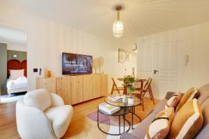 uma sala de estar com um sofá e uma mesa em Amazing apartment 4P/1BR with small garden em Paris