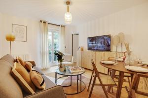 uma sala de estar com um sofá e uma mesa em Amazing apartment 4P/1BR with small garden em Paris