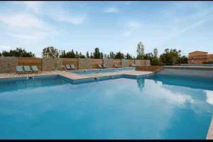a large swimming pool with blue water in it at Appartement T2 cosy à San ciprianu in Lecci