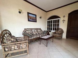 a living room with couches and a table and chairs at Hotel Quinta Maya in Flores