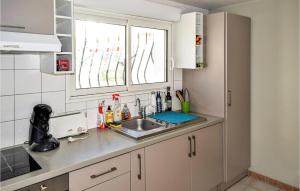 una pequeña cocina con fregadero y ventana en Gorgeous Apartment In Saint-pe-sur-nivelle With House A Panoramic View en Saint-Pée-sur-Nivelle