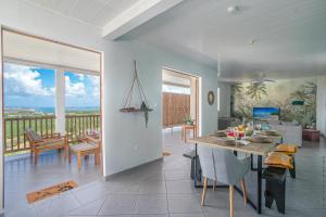 comedor y sala de estar con vistas al océano en Haut de villa au François, en Le François