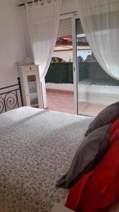 a bedroom with a bed and a large window at Fantástico apartamento con piscina en Tossa de Mar in Tossa de Mar