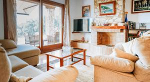 sala de estar con 2 sofás y chimenea en Cal Nano Casa Rural, en Vall-Llobrega