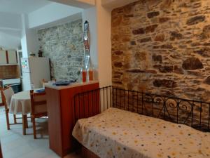 sypialnia z łóżkiem i kamienną ścianą w obiekcie Myrtle w mieście Engares