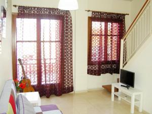 a living room with two windows with red curtains at Mat Old Town Apartments L in Rethymno