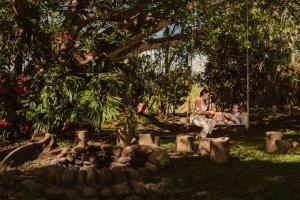 uma mulher e uma criança sentadas num baloiço num parque em Gateway to Paradise em Tilarán