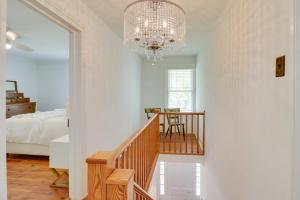 a bedroom with a chandelier and a staircase with a bed at Quiet Farmhouse on 77 Acres Near Shenandoah River! in Elkton