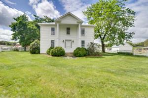 an old white house with a grassy yard at Quiet Farmhouse on 77 Acres Near Shenandoah River! in Elkton