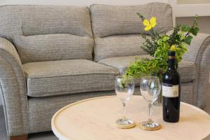 a bottle of wine and two glasses on a table at Rossett Pike in Bowness-on-Windermere