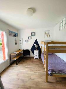 ein Schlafzimmer mit einem Etagenbett, einem Schreibtisch und einem Schreibtisch in der Unterkunft Maison - Terrasse - Jardin in Préchacq