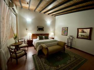 a bedroom with a bed and a table and chairs at Posada El Remanso de Pueblo Nuevo in San Cristóbal +108 photos