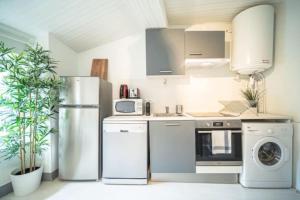 a kitchen with a refrigerator and a washing machine at Le San Diego - Appartement 4 pers Oullins-Lyon in Oullins