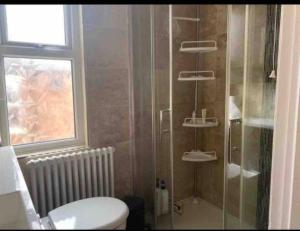 baño con aseo y ducha y ventana en 7 Bed Home*Contractors*CityCentre*FREE Parking en Derby