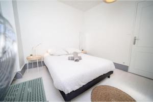 um quarto com uma cama com um urso de peluche em Le San Diego - Appartement 4 pers Oullins-Lyon em Oullins