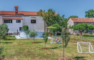 a house with a yard with a soccer goal at Apartment Glavani with Pool in Barban