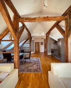 a dining room and living room with wooden beams at Apartmány Bašta & Wellness in Sušice