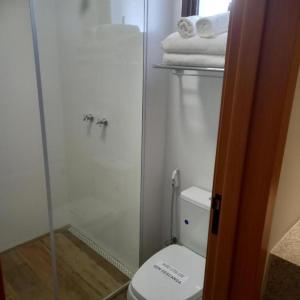 W łazience znajduje się toaleta i przeszklony prysznic. w obiekcie Quinta Santa Bárbara Eco Resort w mieście Pirenópolis