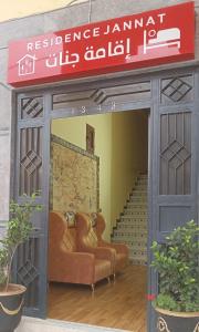 a entrance to a restaurant with two couches and stairs at Résidence Jannat in Ouarzazate