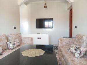 a living room with two couches and a table at Résidence Jannat in Ouarzazate