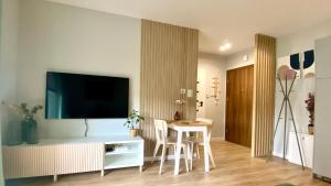 a living room with a table and a flat screen tv at Apartament Centrum z Garażem podziemnym in Bielsko-Biała