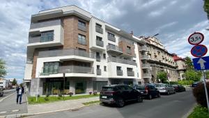 a tall building with cars parked in front of it at Apartament Centrum z Garażem podziemnym in Bielsko-Biała