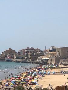 a beach with many umbrellas and people in the water at Casa Rosette in Pozzallo