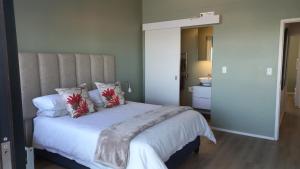 een slaapkamer met een groot wit bed met rode kussens bij A Superb apartment in Still Bay in Stilbaai