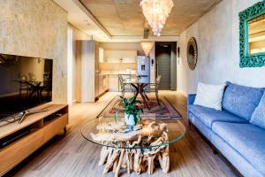uma sala de estar com um sofá azul e uma mesa em Belina - Matrix Premier na Cidade do Cabo