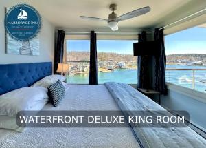 a bedroom with a bed with a large window at Harborage Inn on the Oceanfront in Boothbay Harbor