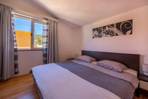 a bedroom with a bed and a large window at Isola Bella in Korčula