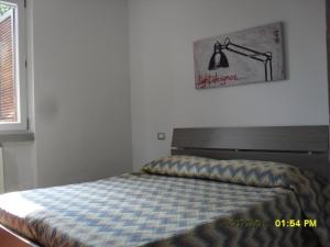 1 dormitorio con 1 cama y 1 lámpara en la pared en Piccolo Paradiso, en Sarnico