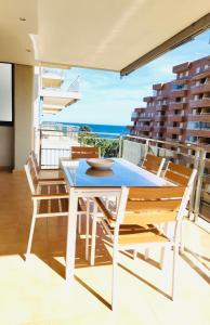 einen Tisch und Stühle auf einem Balkon mit Meerblick in der Unterkunft Las Terrazas - Primera línea de playa con Netflix, Disney, Movistar con todo el fútbol, series, cine y Prime Video in Oropesa del Mar