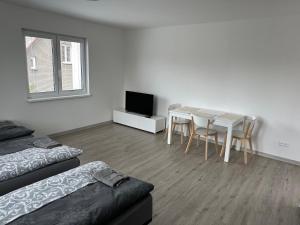 オストラヴァにあるApartmány Liberty Ostravaの白い部屋(テーブル付)とダイニングルーム