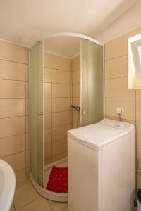 a bathroom with a shower and a white refrigerator at Isola Bella in Korčula +13 photos