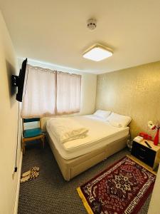 ein kleines Schlafzimmer mit einem Bett und einem Fenster in der Unterkunft UNIQUE PRIVATE ROOMS in Bolton