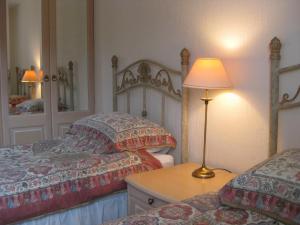 a bedroom with two beds and a table with a lamp at Ardmuir in Turriff